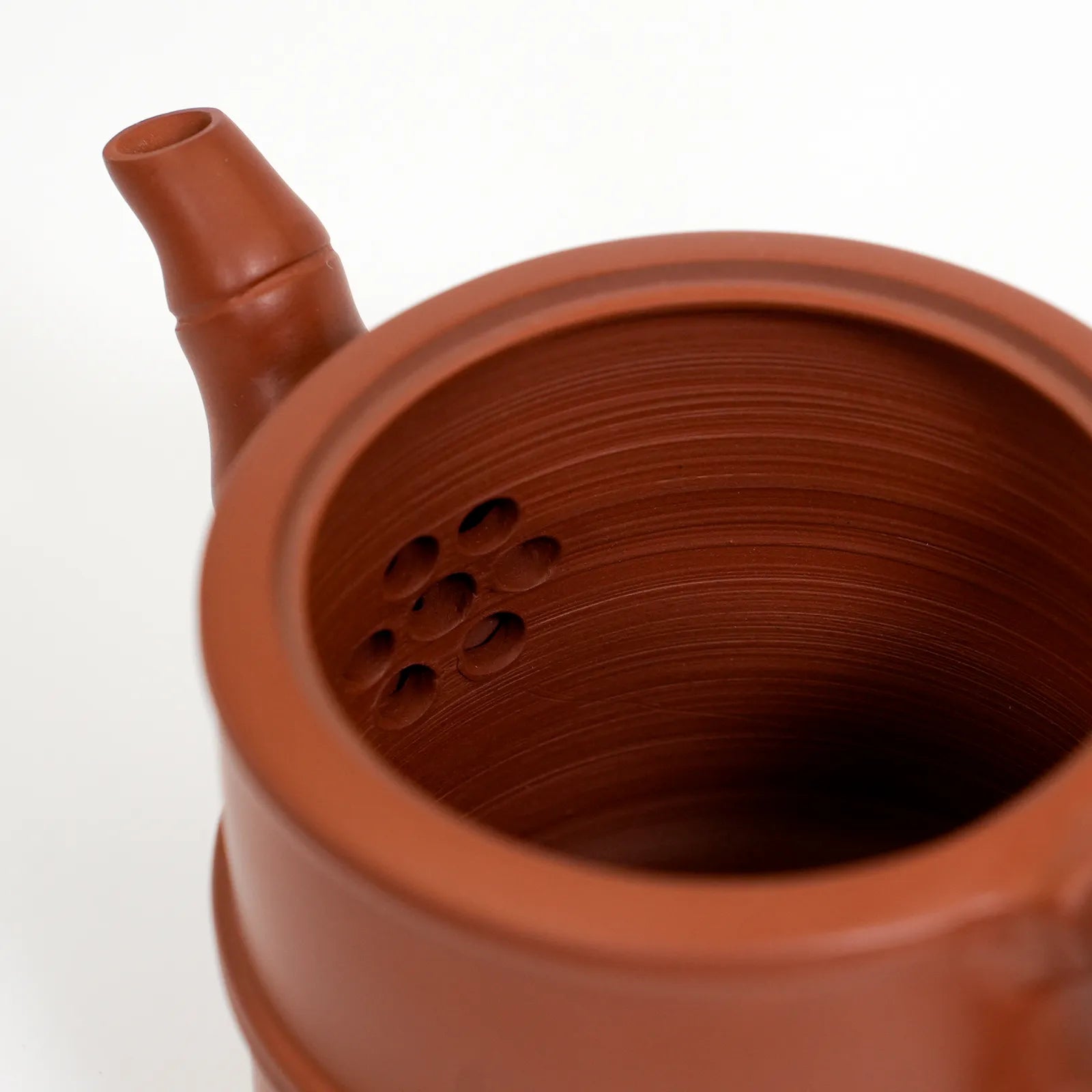 Close-up of a terracotta teapot with a white background