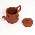 Red clay teapot with lid on a white background