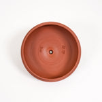 Terracotta pot with engraved text on a white background