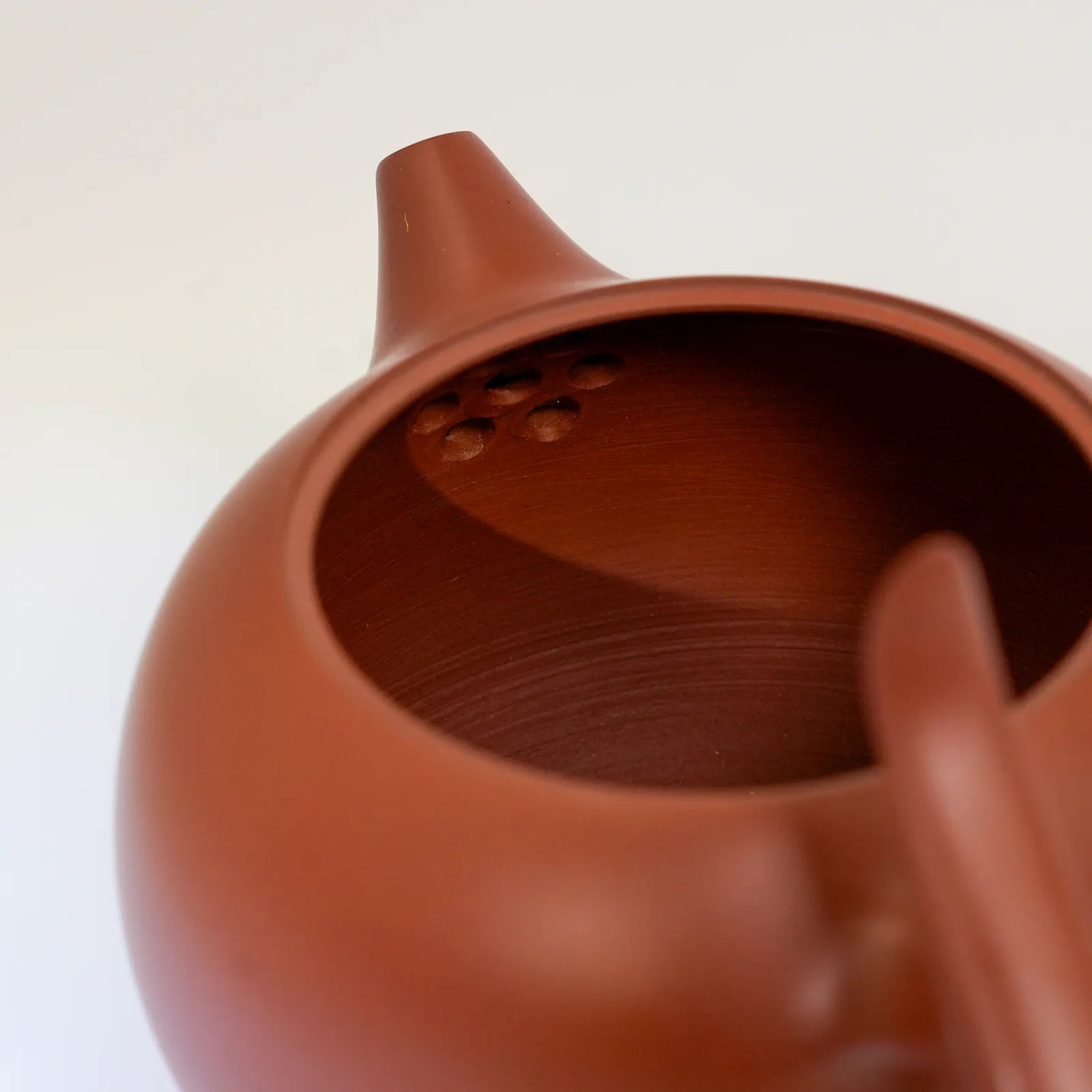 Close-up of a terracotta teapot on a white background