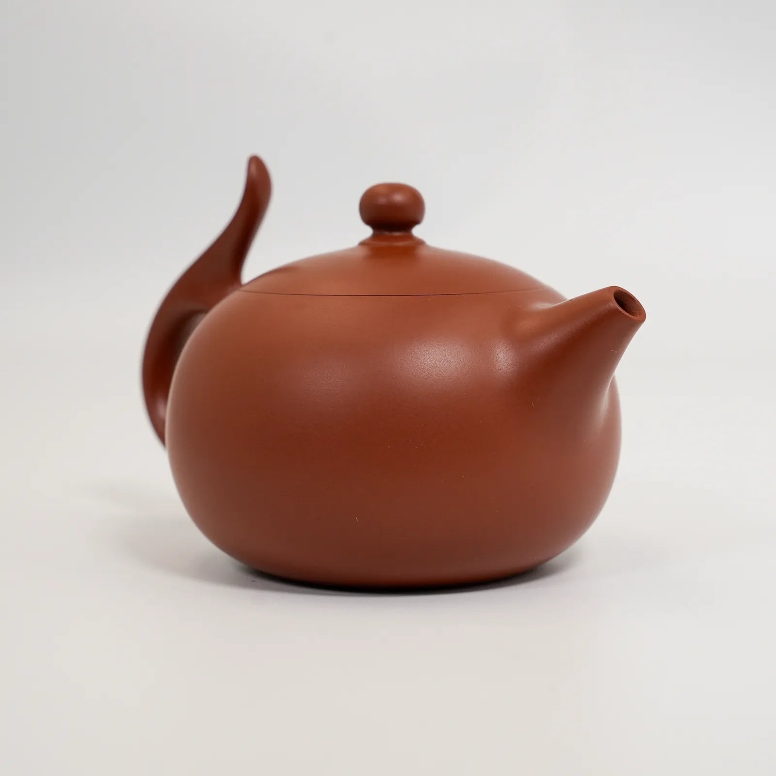 Red ceramic teapot on a white background