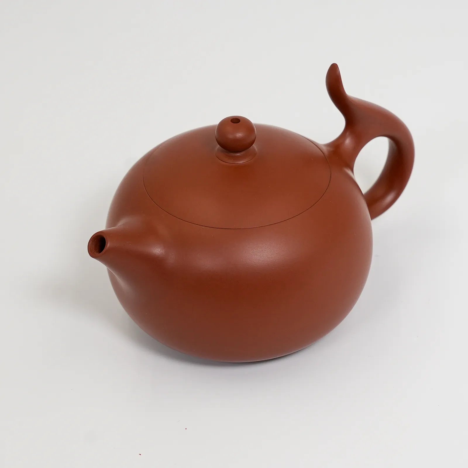 Red ceramic teapot on a white background